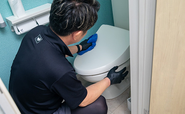 洗面台を清掃する女性清掃員